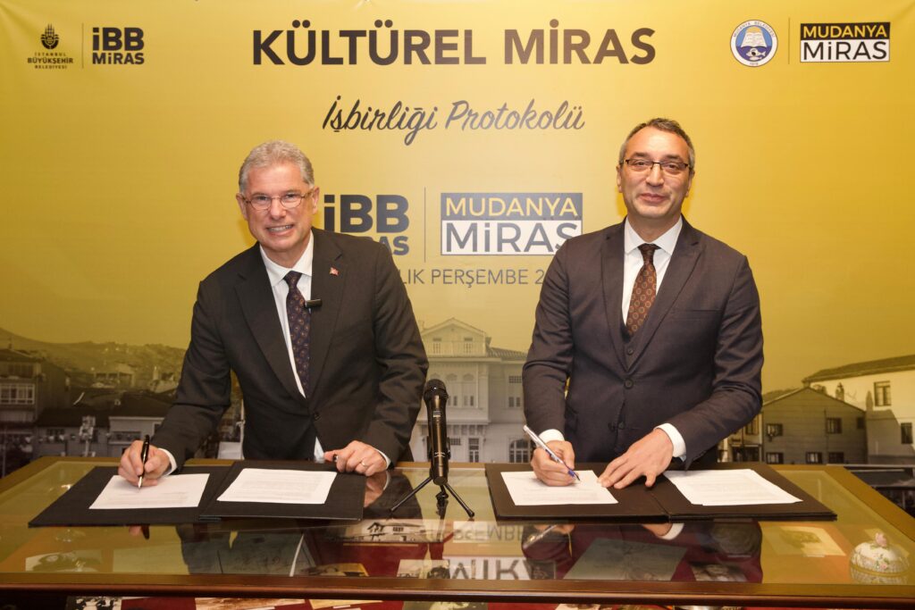 Mudanya Belediyesi ve İstanbul Büyükşehir Belediyesi (İBB), kültürel mirasın korunması ve geleceğe taşınması amacıyla önemli bir adım attı. İki belediye arasında imzalanan Kültürel Miras İşbirliği Protokolü, Mudanya’nın tarihi yapılarının korunmasını ve kurumlar arasında deneyim paylaşımını hedefliyor.
Mudanya Belediyesi, kentin tarihi ve kültürel mirasını korumak, yaşatmak ve gelecek nesillere aktarmak amacıyla önemli bir işbirliği yaptı. İstanbul Büyükşehir Belediyesi (İBB) Kültür Varlıkları Dairesi Başkanlığı (İBB Miras) ile Mudanya Belediyesi arasında Kültürel Miras İşbirliği Protokolü imzalandı. 
Girit Mahallesi’nde gerçekleşen kültürel gezinin ardından Tahir Paşa Konağı’nda düzenlenen imza törenine Mudanya Belediye Başkanı Deniz Dalgıç, İBB Genel Sekreter Yardımcısı Dr. Mahir Polat, İBB Kültür Varlıkları Dairesi Başkanı Oktay Özel, Mudanya Belediyesi bürokratları ile İBB Miras ekibi katıldı. İmzalanan protokol ile yapılan işbirliğinin önemine vurgu yapan Mudanya Belediye Başkanı Deniz Dalgıç, “İBB Miras’ın daha önce yaptıkları ve birikimleri bize önemli bir yol gösterici olacaktır. Mudanya, Türk tarihinin her dönemine tanıklık etmiş önemli ve özel bir ilçedir. Birlikte yapacağımız çok iş var. İlk işimizin de kimliğimizi hatırlamak ve kültürel mirasımıza sahip çıkmak olduğunu düşünüyoruz. Bu işbirliğini dokuz aylık hizmet dönemimizde attığımız en önemli adımlardan biri olarak görüyoruz” dedi.
“MUDANYA İLE İŞBİRLİĞİNE HAZIRIZ”
2019 yılında Ekrem İmamoğlu’nun göreve gelmesiyle “Kentlerin tarihi kimliği olmadan, geleceği olmaz” vizyonuyla İBB Miras’ın temellerinin atıldığını belirten İBB Genel Sekreter Yardımcısı Dr. Mahir Polat, “Beş sene içerisinde bin iki yüzün üzerinde tarihi alana dokunan, bu alanda eksik bırakılmış tüm noktaları doğru metotla günümüze kazandıran bir deneyim yaşadık. İBB miras Türkiye’nin ortak değeridir. Mesleğimizi ve birikimimizi bu topraklar için paylaşmaya hazırız” dedi. Mudanya’da özgün bir dokunun olduğuna da değinen Polat, şöyle konuştu:
“Mudanya’nın dokusu oldukça güçlü. İyi bir mimari kimliği ve tarihi kent dokusu var. Mudanya’da duyarlı, konuya çok hakim bir belediye başkanı ve eşiyle karşılaştık. Duyarlılığınız bizim için çok önemliydi. Biz inanıyoruz ki, bu tür duyarlılıklar kentlere çok şey katacaktır. İBB Miras olarak Mudanya için elimizden geleni yapmaya, tüm bilgi, birikim ve tecrübemizi dayanışmayla sunmaya hazırız. Yapacağımız işlerle Mudanya’ya güzel şeyler katacağız.”
İmzalanan protokol kapsamında, İstanbul Büyükşehir Belediyesi ve Mudanya Belediyesi arasında deneyim aktarımın sağlanması ve kültürel mirasın korunması hedefleniyor. Ayrıca işbirliğinin geliştirilerek, deprem güçlendirme ve restorasyon konularında vatandaşlara destek olmak için “Miras Ofisleri”nin kurulması amaçlanıyor. 
